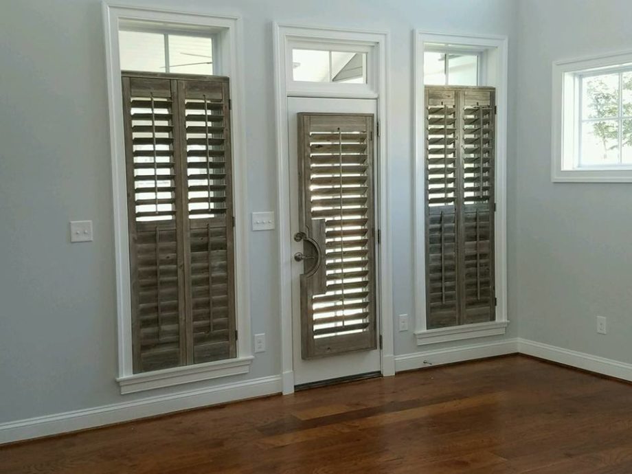 Drift wood shutters adorn a door and two windows in Charlottesville, Virginia.